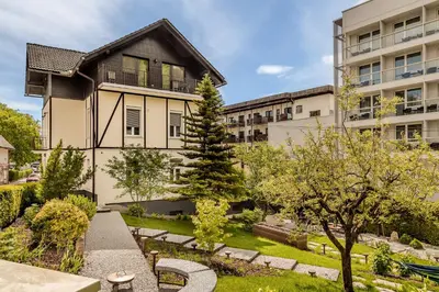 an apartment building with a garden in front of it at Guest House The Hive in Bled