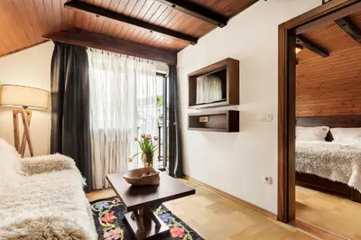 a living room with a bed and a mirror at Guest House The Hive in Bled