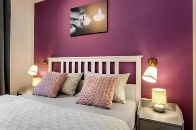 a bedroom with purple walls and a bed with pillows at Garden House 202 by Sigismundi in Brežice