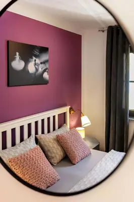 a bedroom with purple walls and a bed with two pillows at Garden House 202 by Sigismundi in Brežice