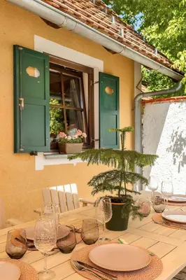 a wooden table with plates and wine glasses on it at Garden House 202 by Sigismundi in Brežice