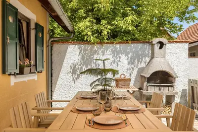 a wooden table with plates and glasses on a patio at Garden House 202 by Sigismundi in Brežice