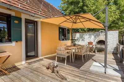 a patio with a table and an umbrella on a deck at Garden House 202 by Sigismundi in Brežice