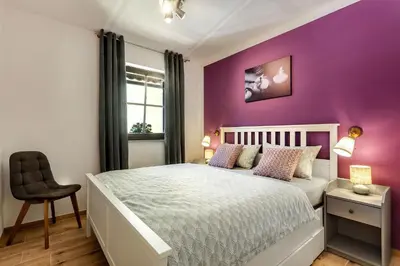 a purple bedroom with a white bed and a chair at Garden House 202 by Sigismundi in Brežice