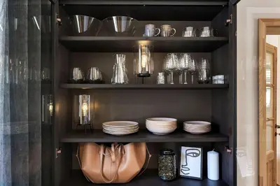 a black shelf with plates and glasses on it at Garden House 202 by Sigismundi in Brežice