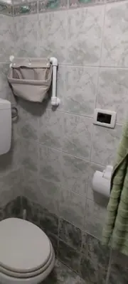 a bathroom with a toilet and a tiled wall at Apartma Dajana in Lokve