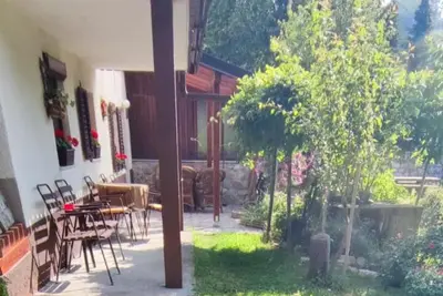 a patio of a house with a table and chairs at Apartma Dajana in Lokve