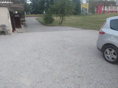 a car parked in a gravel parking lot at APARTMA Črnomelj in Črnomelj
