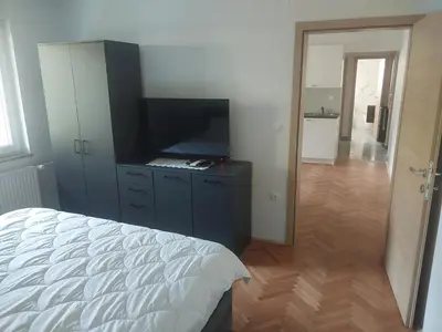 a bedroom with a bed and a flat screen tv at APARTMA Črnomelj in Črnomelj