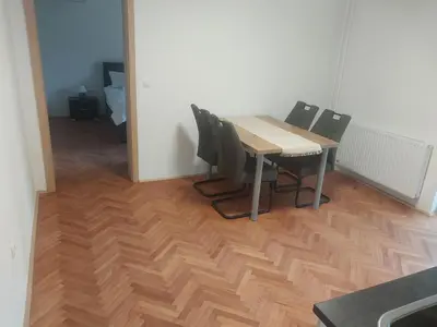 a table and chairs in a room with a wooden floor at APARTMA Črnomelj in Črnomelj