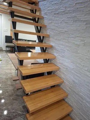 a wooden staircase in a room with a brick wall at Sun House Luka in Radmirje