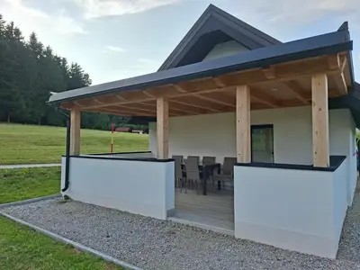 a pavilion with a deck in a field at Sun House Luka in Radmirje