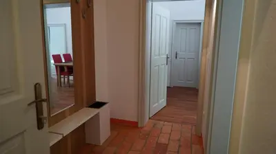 a hallway with a door and a mirror and a table at Snežnik castle estate in Stari Trg pri Ložu