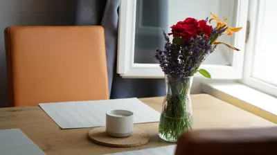 a vase of flowers sitting on a table with a cup at Snežnik castle estate in Stari Trg pri Ložu