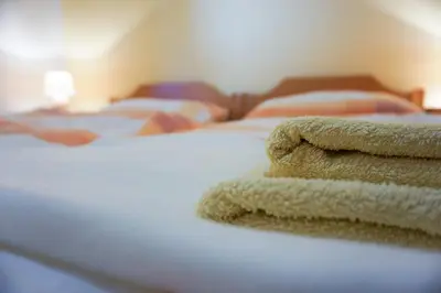 a towel is sitting on the edge of a bed at Apartments Kravanja in Bovec