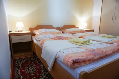 two twin beds in a bedroom with two lamps at Apartments Kravanja in Bovec
