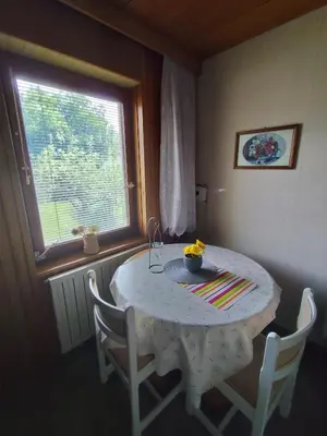 a white table with chairs and a window at Traditional Bled Stay in Bled