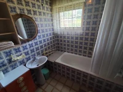 a bathroom with a tub and a sink and a mirror at Traditional Bled Stay in Bled