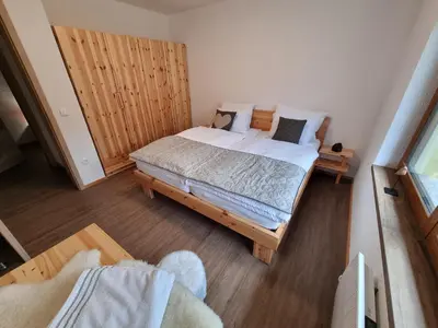 a bedroom with a bed with a wooden headboard at Luna's Mountain House - Jezersko in Zgornje Jezersko