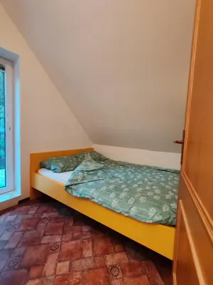 a small bedroom with a bed in a attic at Apartma Pohorc - Kostanj in Pohorje