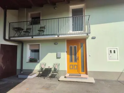 a building with a yellow door and a balcony with chairs at Frane House in Knežak