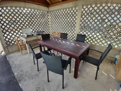 a wooden table and chairs in an outdoor room at Frane House in Knežak