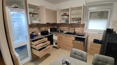 a kitchen with an open refrigerator with two chairs in it at Frane House in Knežak