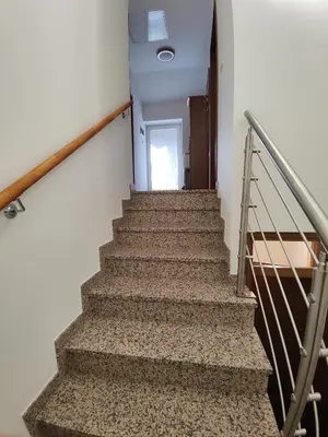 a staircase in a building with a stair railing and a door at Frane House in Knežak