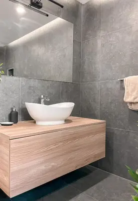 a bathroom with a white sink on a wooden counter at Rustikal Apartment with Garden and Free Parking in Ljubljana
