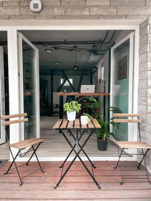 a table on a porch with two chairs and plants at Rustikal Apartment with Garden and Free Parking in Ljubljana