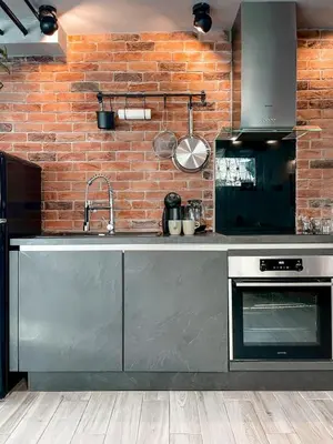 a kitchen with a sink and a brick wall at Rustikal Apartment with Garden and Free Parking in Ljubljana