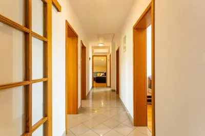 a hallway of a house with doors and a tile floor at Apartment in the Village in Petrovče