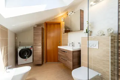 a bathroom with a sink and a washing machine at Apartment in the Village in Petrovče