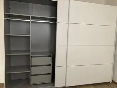 a closet with white drawers and a white wall at Nice apartment in Celje in Celje