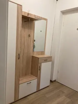 a wooden cabinet with a mirror in a room at Nice apartment in Celje in Celje