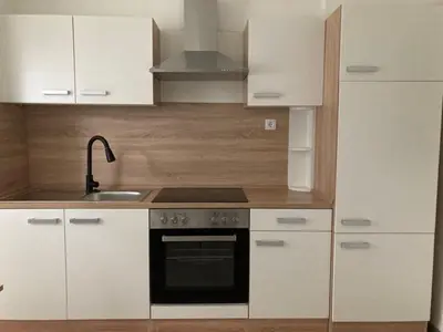 a kitchen with white cabinets and a stove top oven at Nice apartment in Celje in Celje