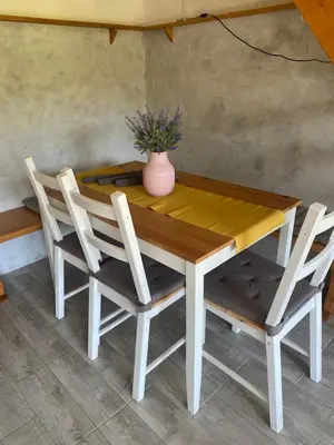 a wooden table with two chairs and a vase on it at Počitniška hiša Lily in Idrija