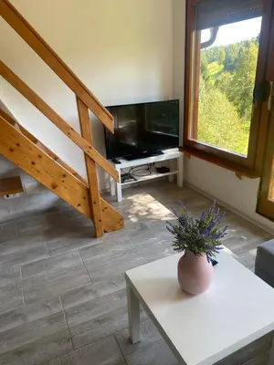 a living room with a television and a table at Počitniška hiša Lily in Idrija