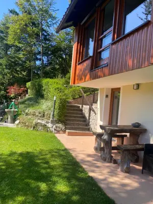 a house with a picnic table next to a lawn at Počitniška hiša Lily in Idrija