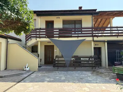 a house with a balcony and a stair case at Suzi Apartments in Lokev