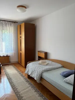 a bedroom with a bed and a cabinet and a rug at Suzi Apartments in Lokev