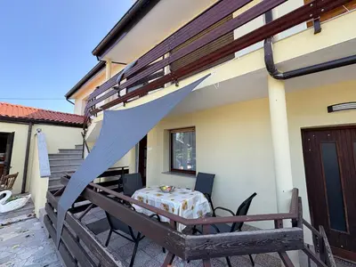 a patio with a table and chairs on a house at Suzi Apartments in Lokev