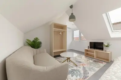 a white living room with a couch and a tv at House Pr'Španc in Ljubljana