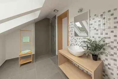 a bathroom with a white sink and a shower at House Pr'Španc in Ljubljana