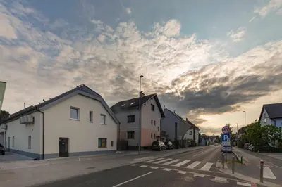 an empty street with buildings and a cloudy sky at House Pr'Španc in Ljubljana