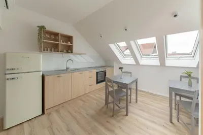 a kitchen with white appliances and a table and chairs at House Pr'Španc in Ljubljana