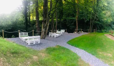 a group of white benches sitting in a park at Glamping - domačija Lamperček in Velenje