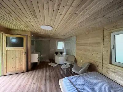 a bedroom with a bed and a bathroom with a tub at Glamping - domačija Lamperček in Velenje