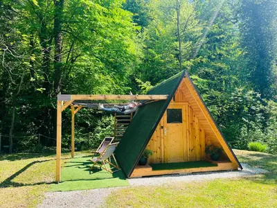 a man laying on a hammock in a shed at Glamping - domačija Lamperček in Velenje