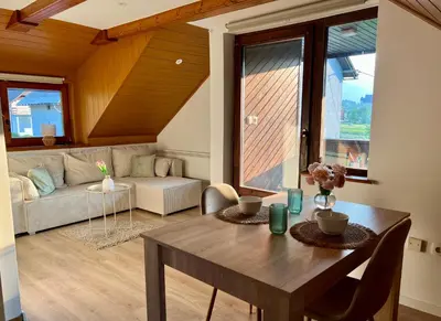 a living room with a table and a couch at Studio Lilly in Bohinj